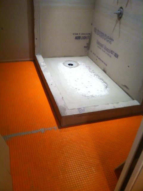 Pan and concrete installed in shower area  -Ditra ( Orange color ) on Floor all ready for tile install